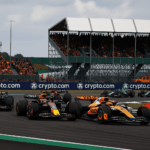 F1 Silverstone 2026 sprint race action with McLaren and Red Bull cars battling on track in front of packed grandstands.