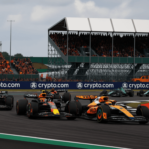F1 Silverstone 2026 sprint race action with McLaren and Red Bull cars battling on track in front of packed grandstands.